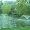 Power House F1000F Pond and Lake Fountain creating stunning water displays in a lush green setting.