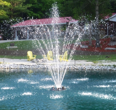 A decorative lake and pond fountain with an intricate spray pattern enhancing the beauty of the water feature.