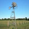 Koenders Windmill standing in a rural field, designed for natural pond aeration.