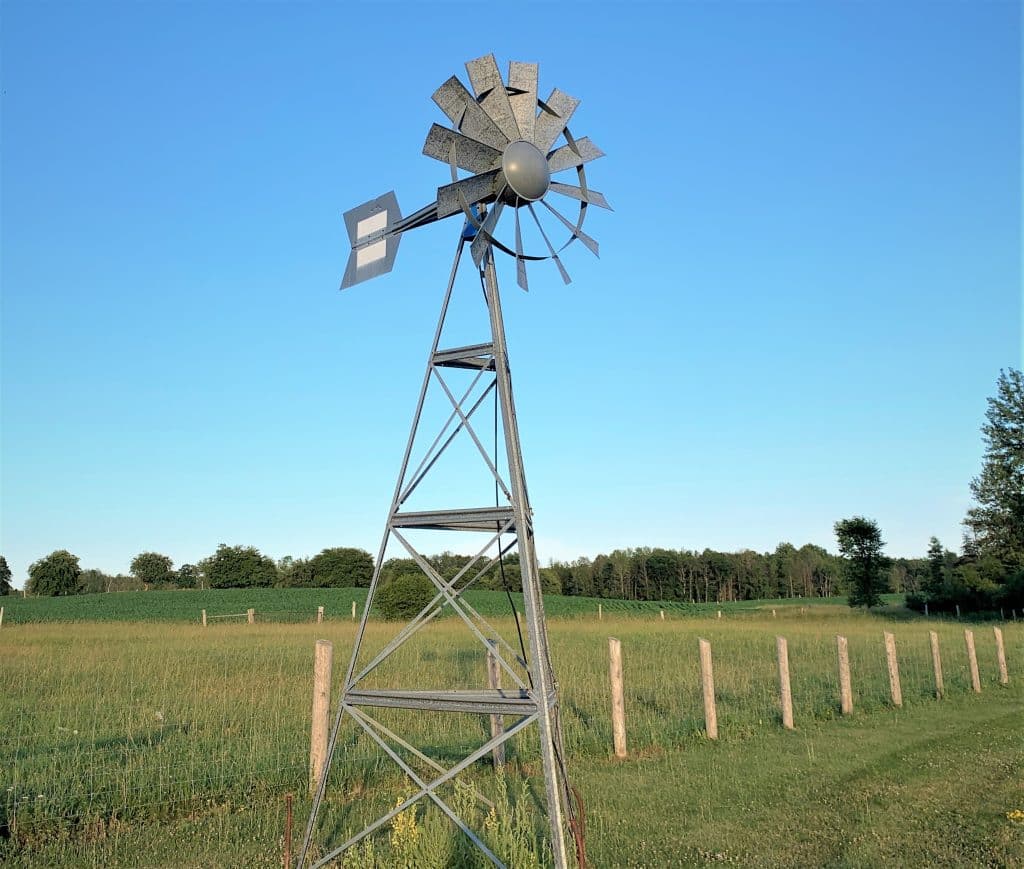 Koenders Windmill standing in a rural field, designed for natural pond aeration.